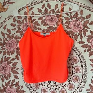 A bright coral or salmon pink top, with spaghetti straps. As well as cropped.